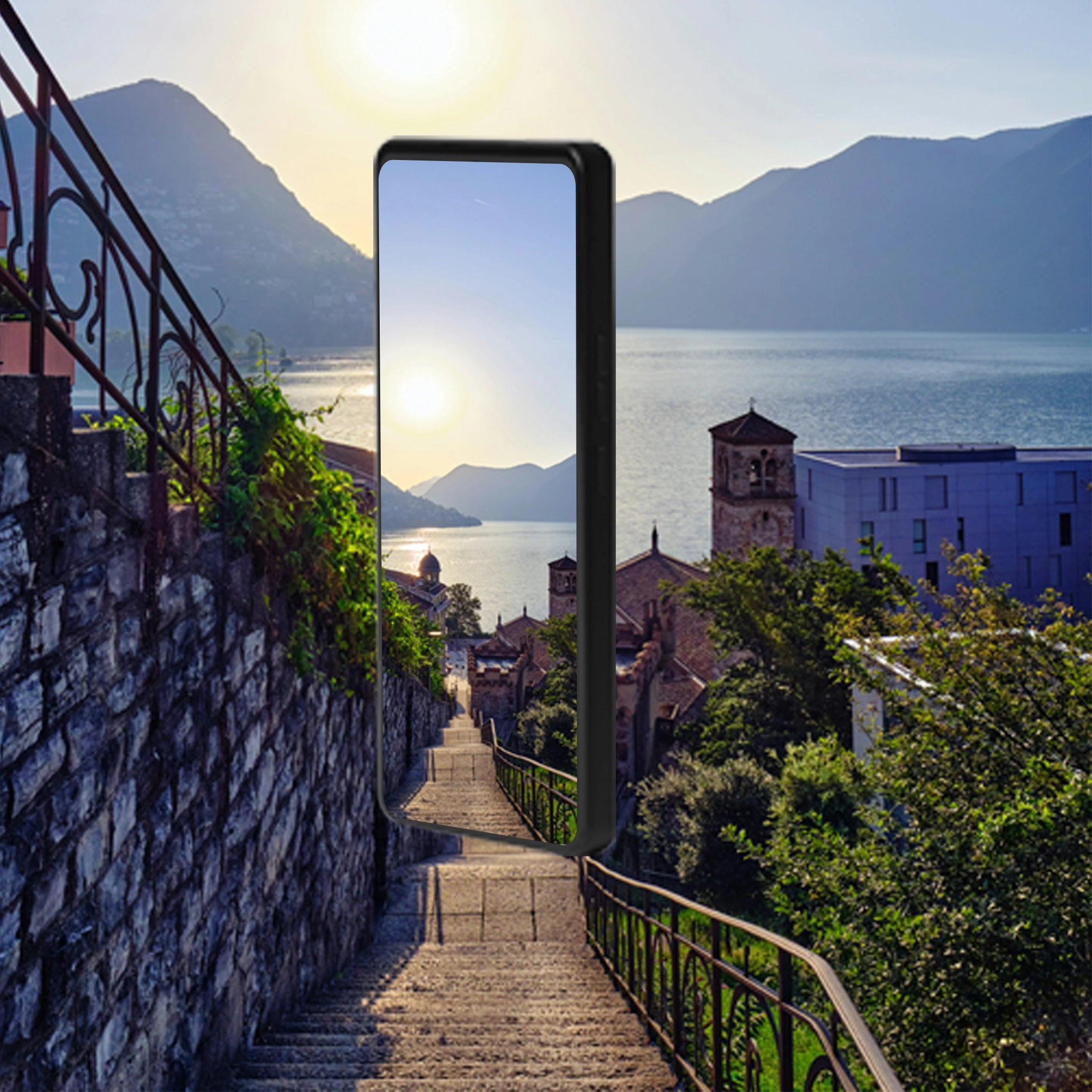 Smartphone displaying a scenic view of a coastal town with mountains and water.