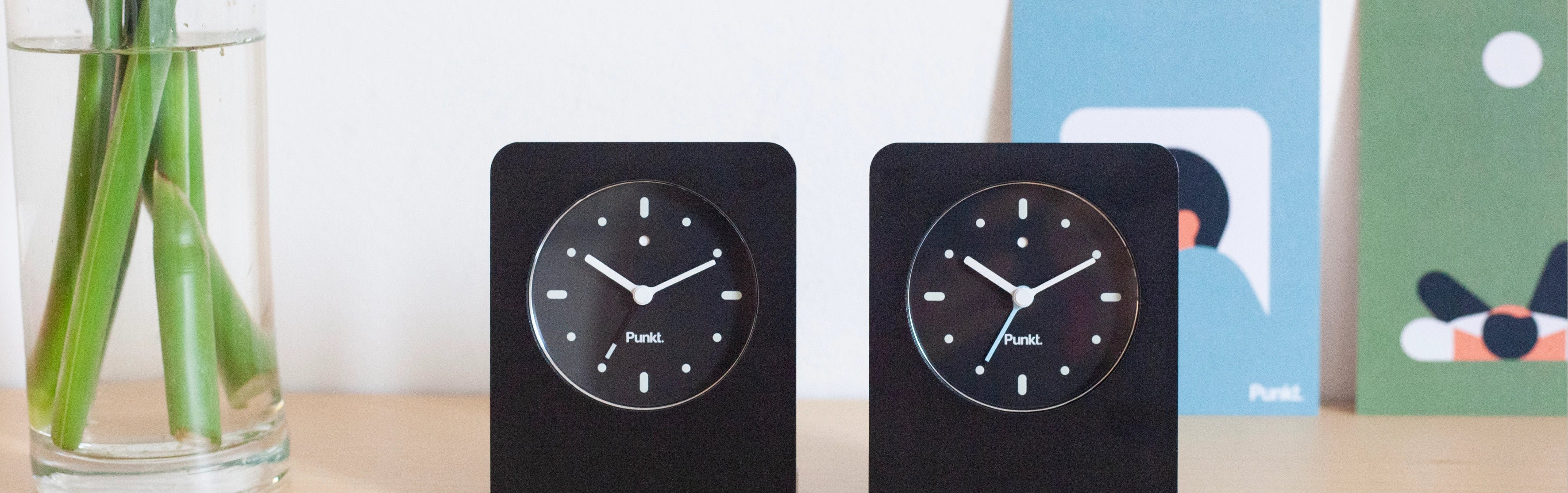 Side-by-side comparison of the Punkt AC02 alarm clocks featuring black and pale blue second hands, highlighting the subtle design difference.