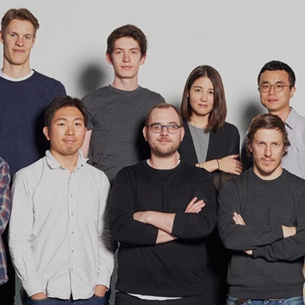 Casual team group photo – Mixed group of six young adults posing together against a neutral background.