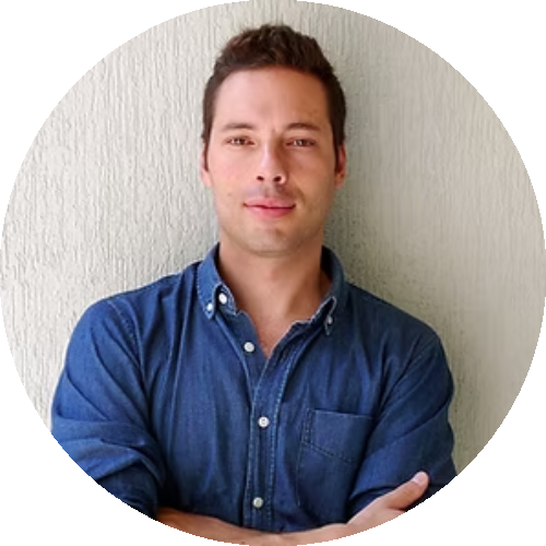 Portrait of Georges Moanack, designer of the Punkt. ES01 Extension Socket, wearing a denim shirt and standing against a neutral background.