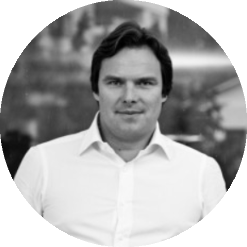 Black and white circular portrait of a man in a light-colored shirt against a softly blurred background.