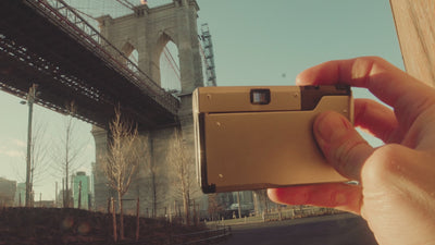 A young man handles a film camera and inspects negatives, followed by a sequence of photo stills overlaid on video scenes of him watching the sunset—evoking simplicity, focus, and the essence of Punkt.'s philosophy.