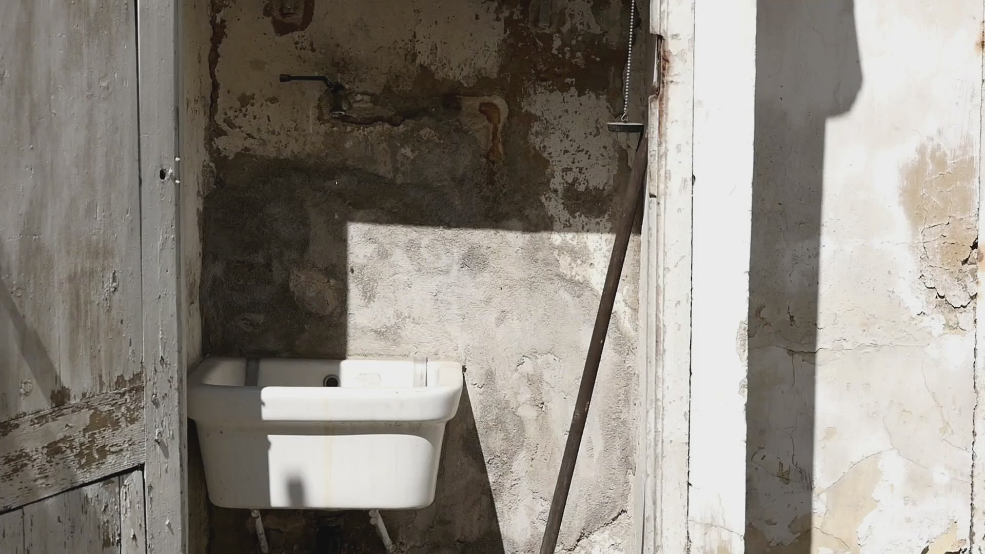 Video thumbnail of a weathered outdoor sink and peeling wall illuminated by bright sunlight, highlighting rustic textures.