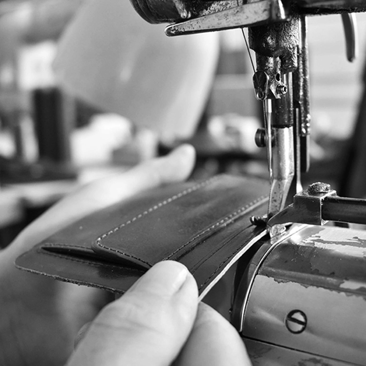 Close-up of artisan hand-stitching a leather phone case on a sewing machine – showcasing Danny P.’s craftsmanship