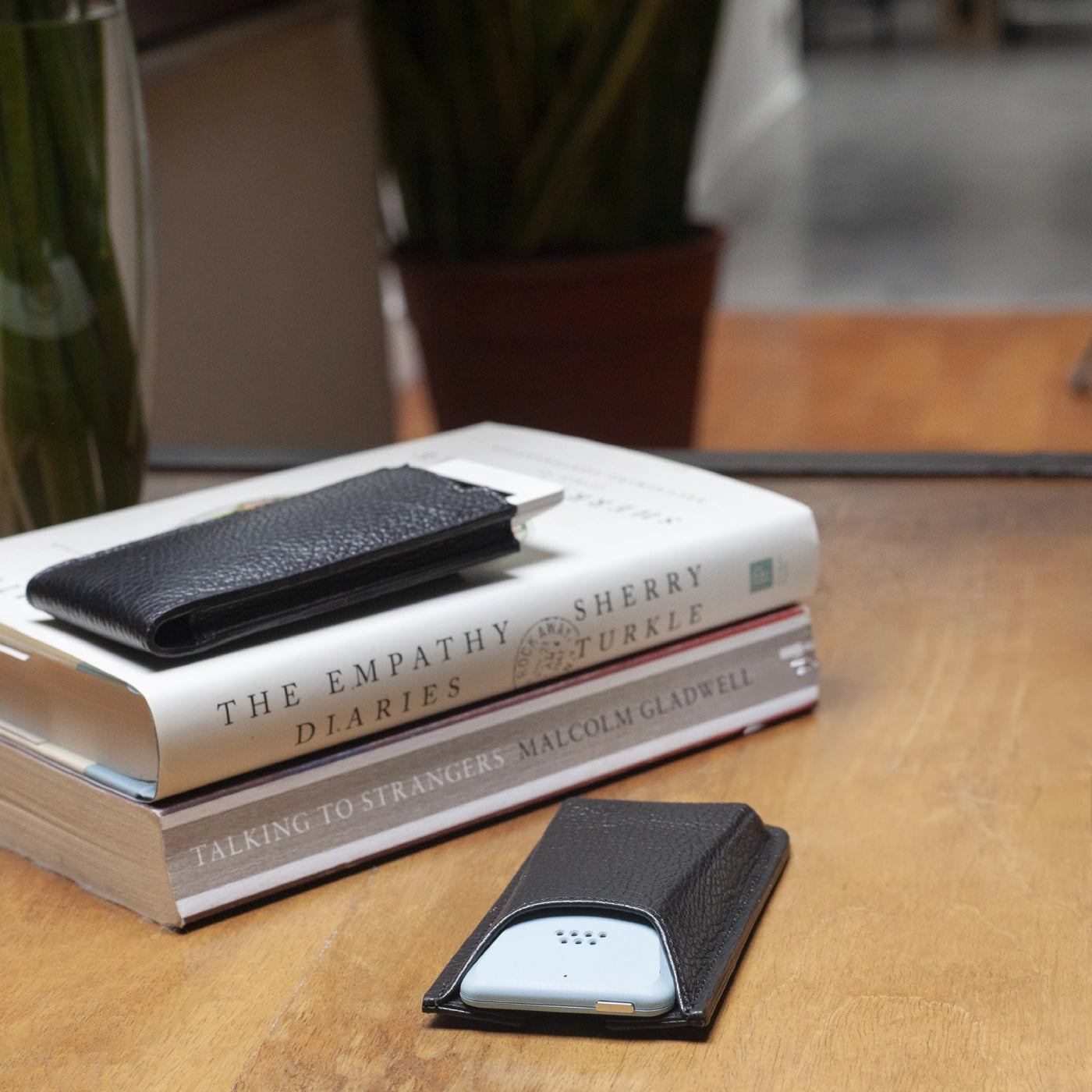 Danny P. leather cases for Punkt. MP02 resting on a stack of books