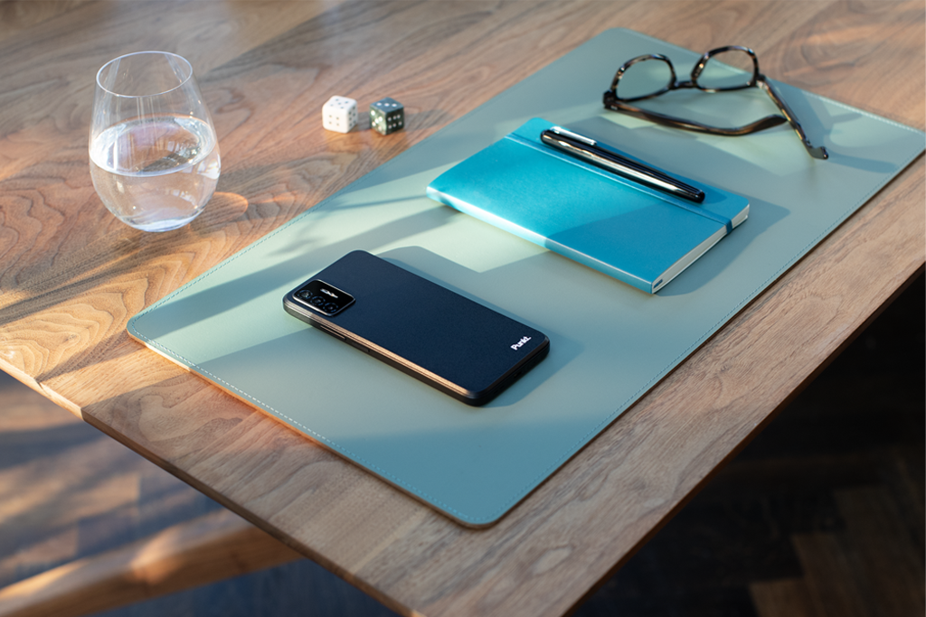 Punkt MC02 smartphone Back Punkt. logo on table with notebook glasses glass of water 