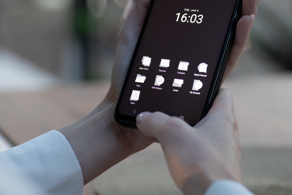 Smartphone MC02 tenuto in mano con schermata con le applicazioni Aphostrophy