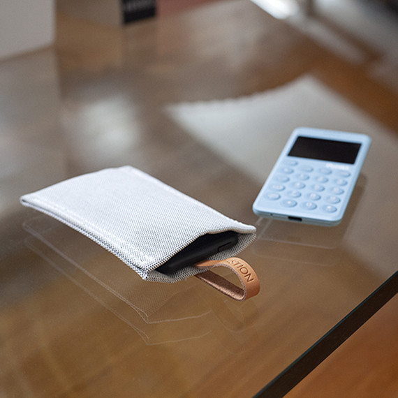 on QWSTION fabric MP02 case with the MP02 black mobile phone covered by the case and the MP02 blue uncovered on a wooden table