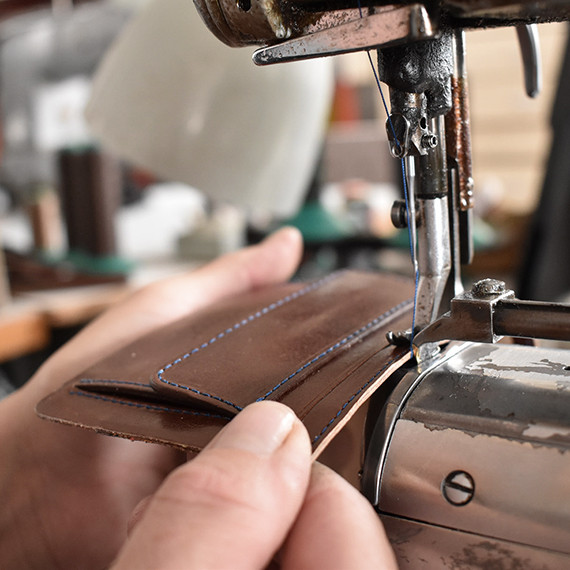 someone from danny P brand sewing a leather case for Punkt. 