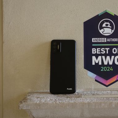 Punkt. MC02 smartphone Black on the back on the wall next to an award from Android Authority at MWC 2024