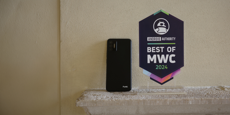 Punkt. MC02 smartphone Black on the back on the wall next to an award from Android Authority at MWC 2024