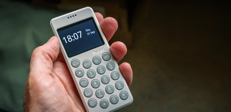Punkt. mp02 light grey phone with time on the screen ihold in one hand