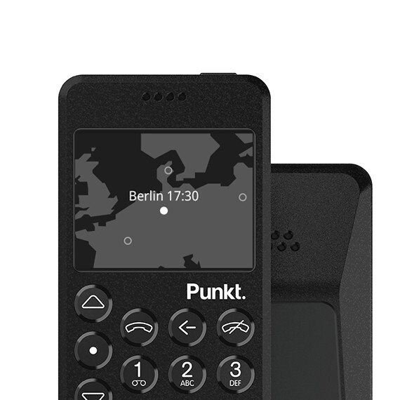 Close-up of the Punkt. MP02 4G minimalist phone in black, showing a map interface with time and location displayed, alongside its physical keypad and sleek design.